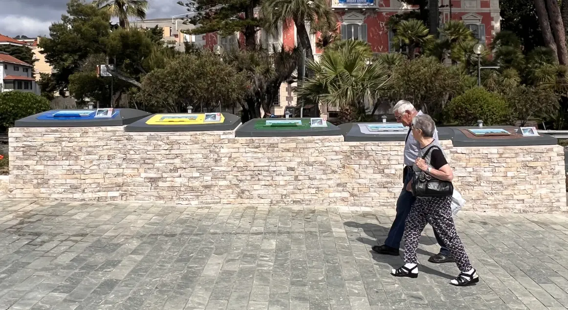 People walking past Semi Underground containers in Diano Marina