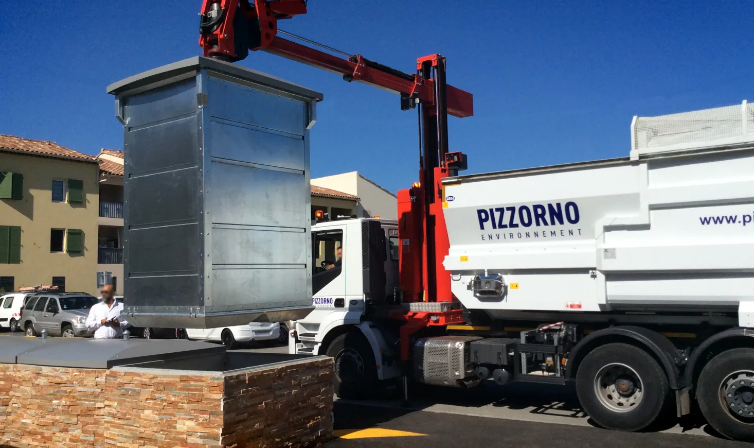 Collection truck lifting an underground container in a town