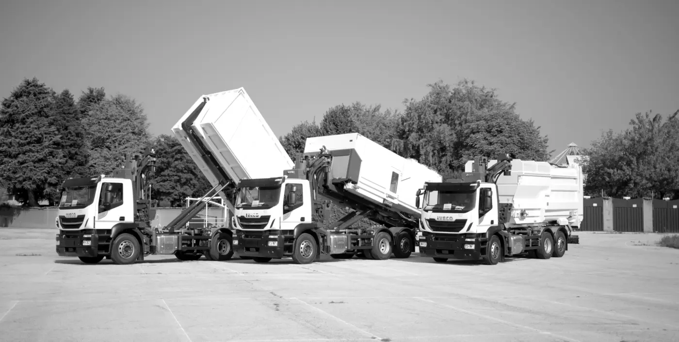 WASE collection trucks lifting containers in a car park